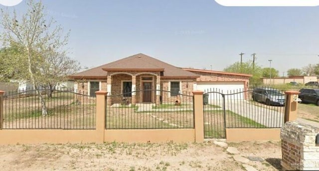 view of front of house with brick siding, a garage, and a fenced front yard