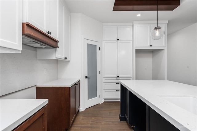 kitchen featuring white cabinets, decorative light fixtures, and dark hardwood / wood-style flooring