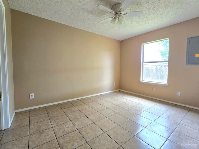 unfurnished room featuring light tile patterned floors, a textured ceiling, electric panel, and ceiling fan