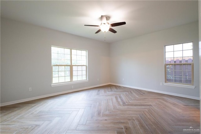 unfurnished room with ceiling fan and light parquet flooring