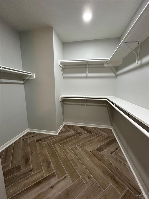 walk in closet featuring dark parquet floors