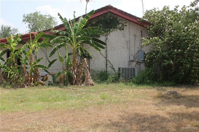 view of side of home featuring central AC and stucco siding