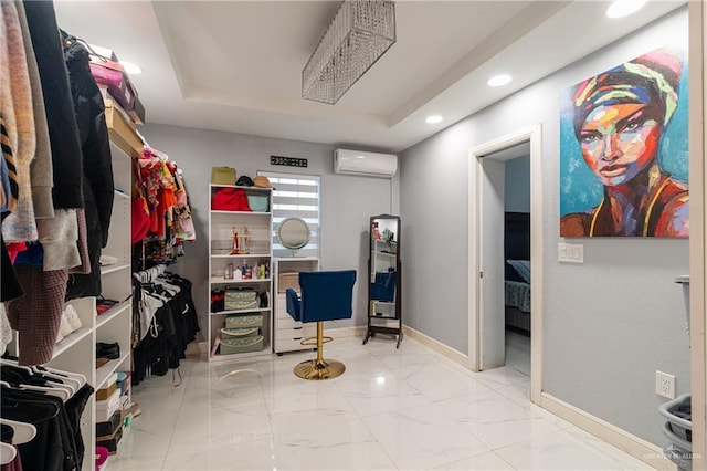 walk in closet with a raised ceiling and an AC wall unit