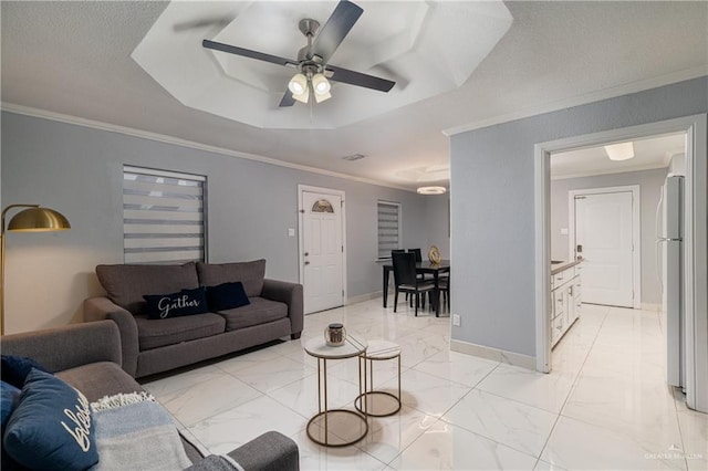 living room featuring ceiling fan, ornamental molding, and a raised ceiling