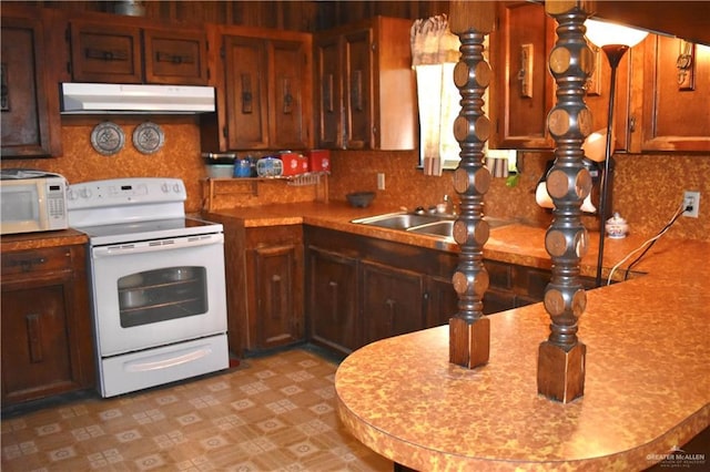 712 N Padre Ave, Weslaco, TX 78596 - kitchen featuring white appliances, under cabinet range hood, light countertops, and a sink