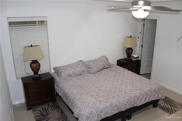 tiled bedroom with baseboards and a ceiling fan