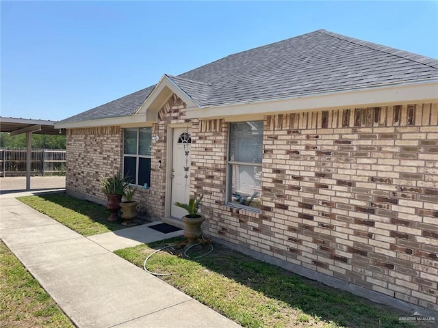2015 W Western St, Edinburg, TX 78539 - entrance to property featuring roof with shingles, fence, and brick siding