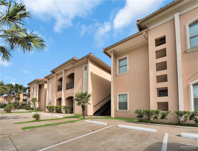 103 Gardenia St Unit 3, South Padre Island, TX 78597 - view of building exterior featuring uncovered parking and stairway