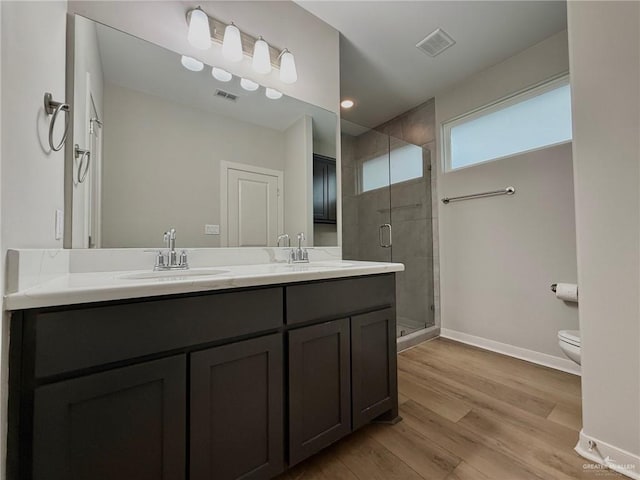 bathroom featuring walk in shower, hardwood / wood-style floors, vanity, and toilet