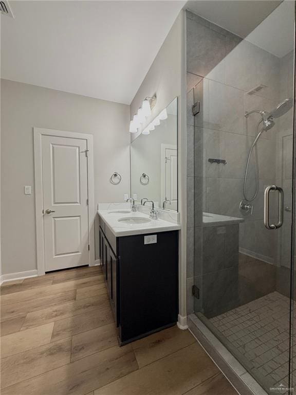 bathroom with vanity, hardwood / wood-style flooring, and a shower with door