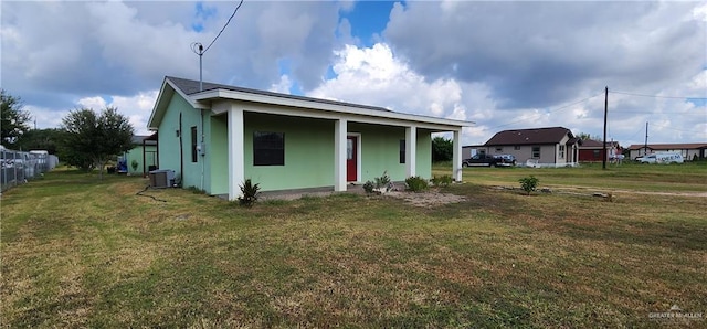 view of front of home with central air condition unit, a front lawn, and a porch