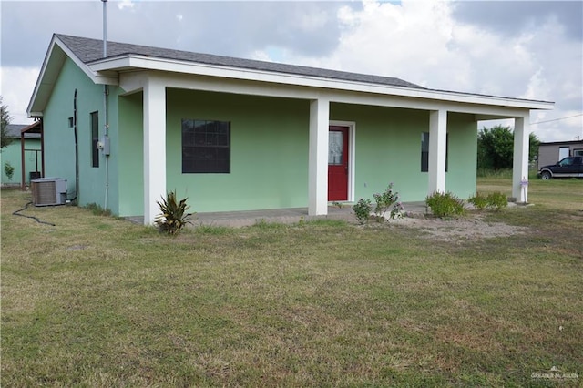 view of front facade with covered porch, central AC unit, and a front yard