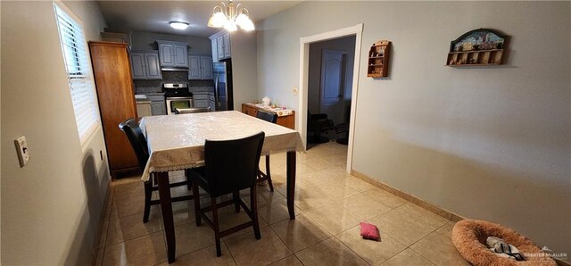 tiled dining space with a chandelier and a healthy amount of sunlight