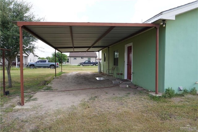 view of vehicle parking featuring a lawn and a carport