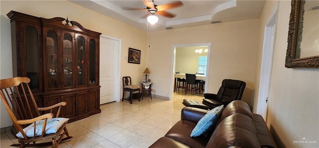 sitting room featuring light tile patterned floors and ceiling fan with notable chandelier