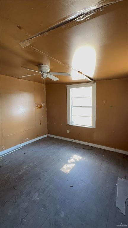 unfurnished room with baseboards and a ceiling fan