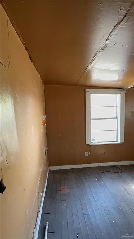 unfurnished room featuring baseboards and hardwood / wood-style flooring