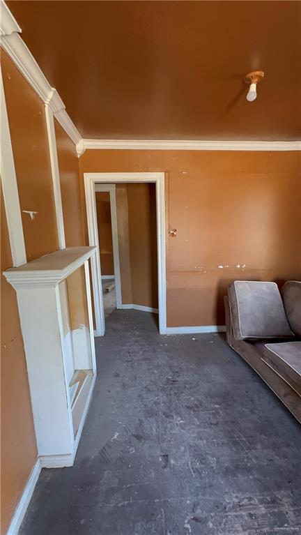 unfurnished living room featuring crown molding and baseboards