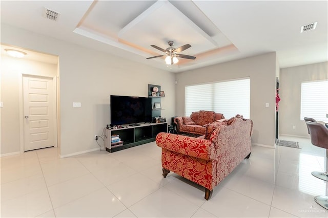 living area with light tile patterned flooring, a raised ceiling, and visible vents