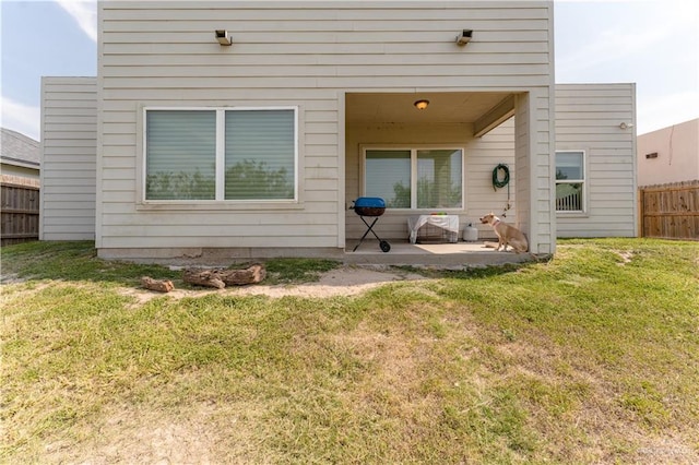 exterior space with a lawn, a patio area, and fence