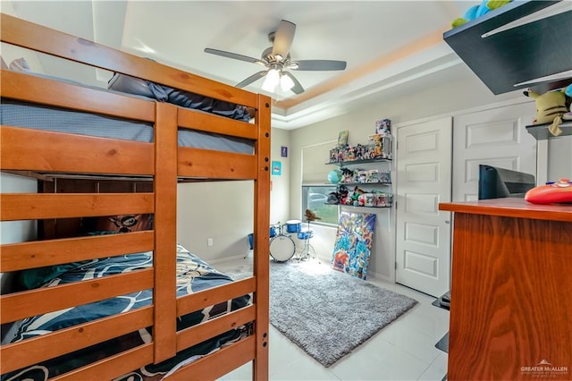 bedroom with ceiling fan and a tray ceiling