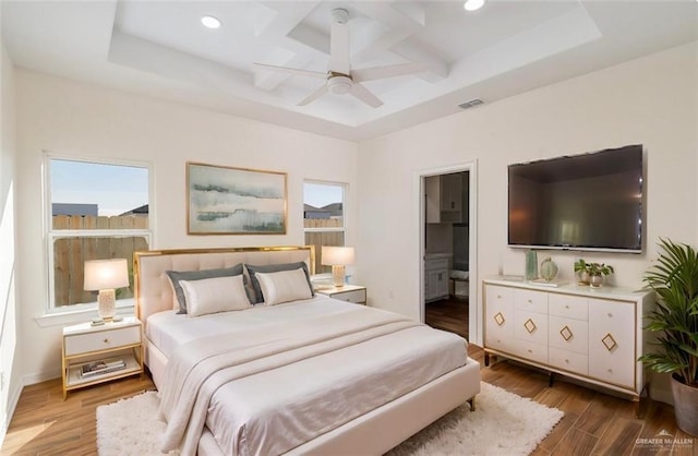 bedroom with hardwood / wood-style flooring, ceiling fan, beam ceiling, coffered ceiling, and connected bathroom