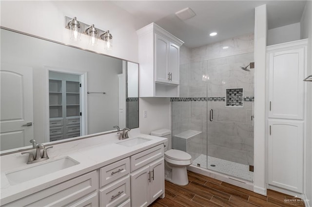 bathroom featuring an enclosed shower, vanity, and toilet