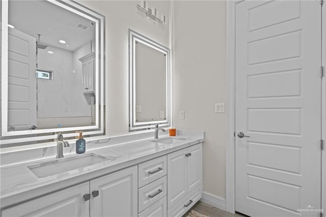 bathroom featuring a shower, hardwood / wood-style floors, and vanity