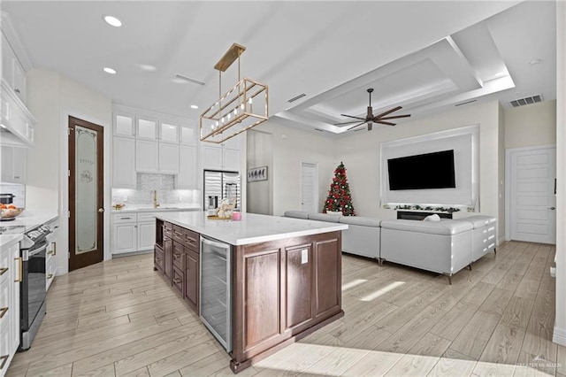 1110 Raptor St, Palmview, TX 78572 - kitchen with beverage cooler, stainless steel appliances, light wood-style flooring, white cabinets, and recessed lighting