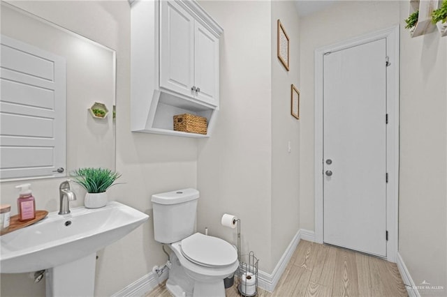 bathroom featuring hardwood / wood-style flooring, toilet, and sink