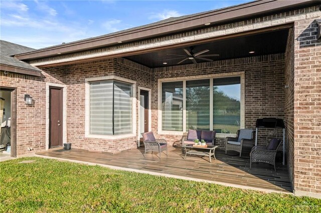 1110 Raptor St, Palmview, TX 78572 - view of exterior entry with ceiling fan, brick siding, a wooden deck, and an outdoor hangout area