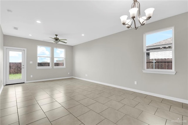 tiled spare room featuring ceiling fan with notable chandelier