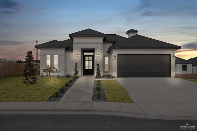 view of front facade with a yard and a garage