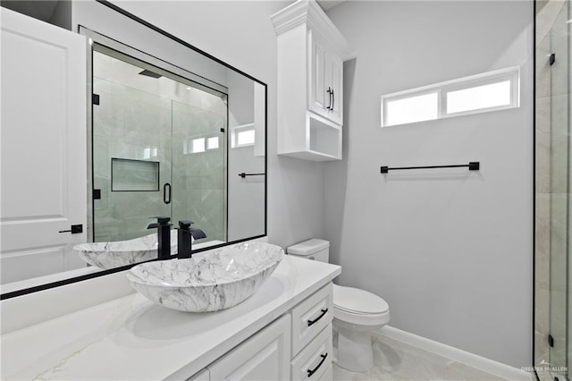 bathroom with vanity, toilet, and a shower with door