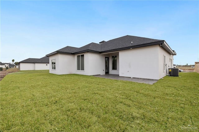 rear view of property featuring central air condition unit, a patio area, and a yard