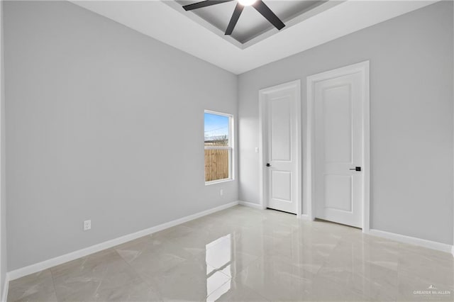 unfurnished bedroom with a raised ceiling and ceiling fan