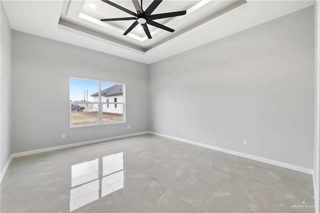 unfurnished room with a tray ceiling and ceiling fan