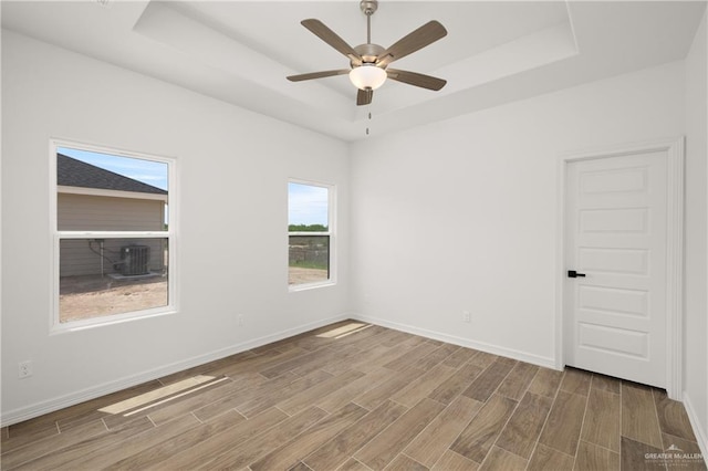 2953 Rio Red Cir, Edinburg, TX 78541 - spare room with a tray ceiling, wood finished floors, a ceiling fan, and baseboards