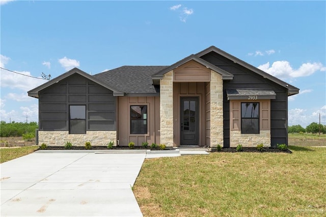 2953 Rio Red Cir, Edinburg, TX 78541 - view of front of property featuring stone siding, a front lawn, board and batten siding, and roof with shingles