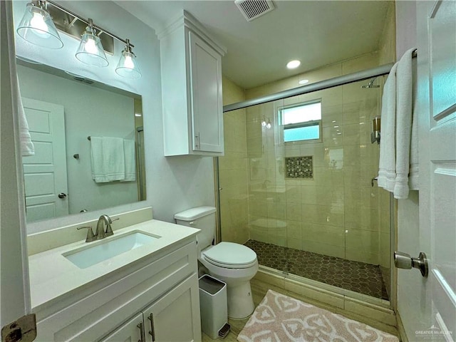 bathroom featuring vanity, toilet, and an enclosed shower