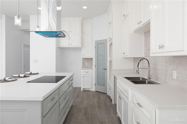 kitchen featuring dark wood-style flooring, a sink, white cabinets, an island with sink, and island exhaust hood