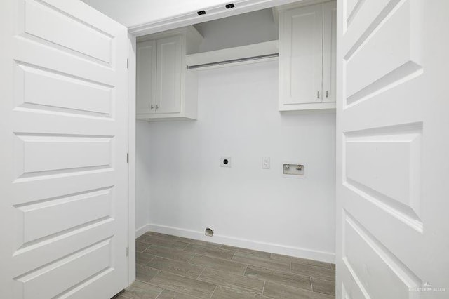 washroom with cabinet space, baseboards, hookup for a washing machine, hookup for an electric dryer, and wood finish floors