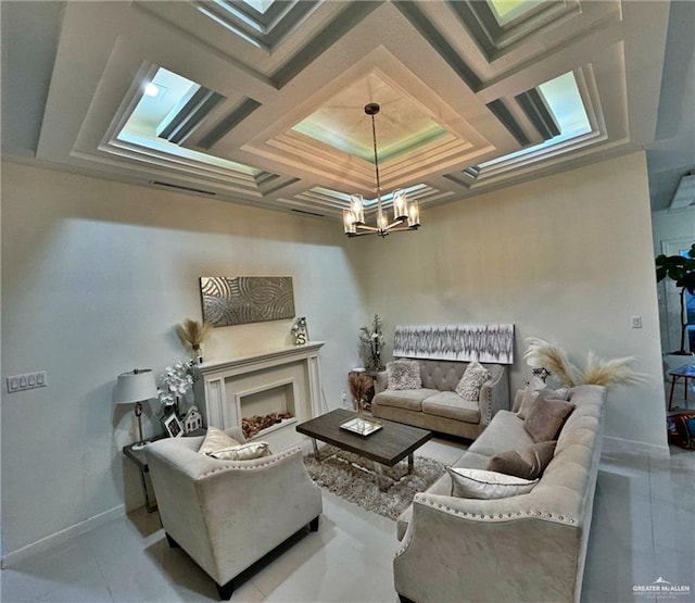 living area featuring a chandelier, tile patterned flooring, coffered ceiling, a fireplace, and baseboards