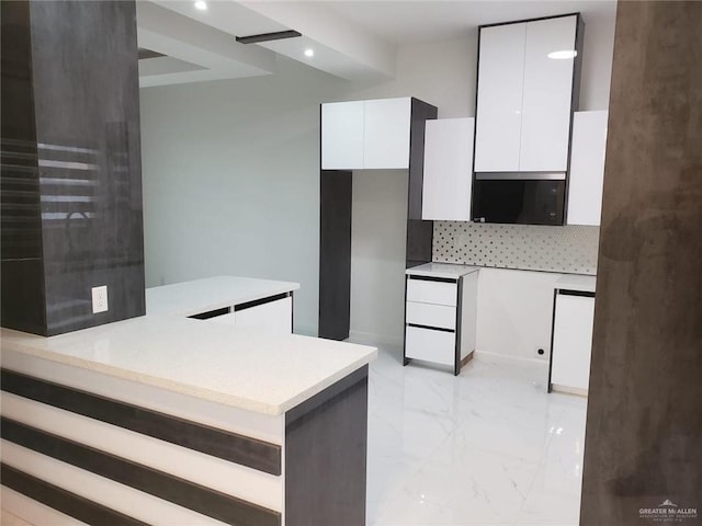 kitchen with marble finish floor, modern cabinets, backsplash, white cabinetry, and light countertops