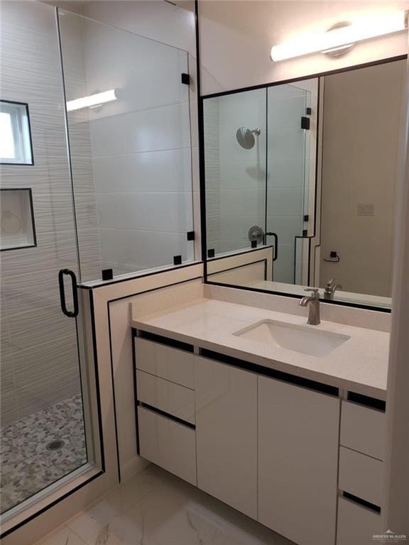 full bathroom featuring marble finish floor, vanity, and a shower stall