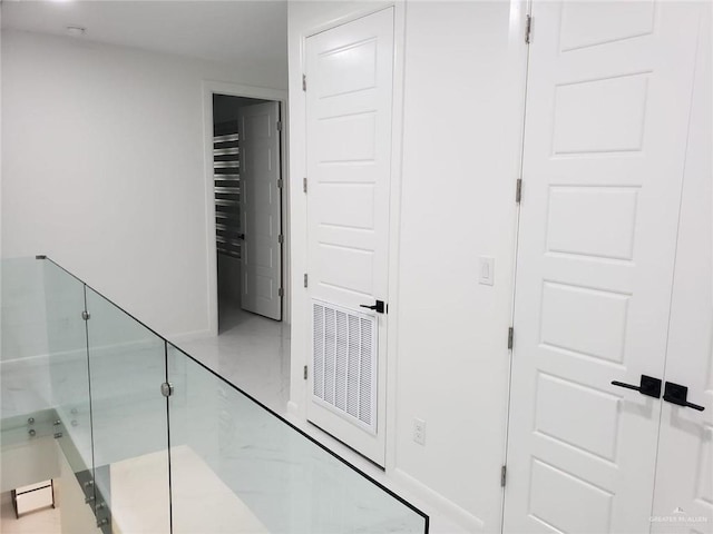 hall with visible vents, marble finish floor, and baseboards