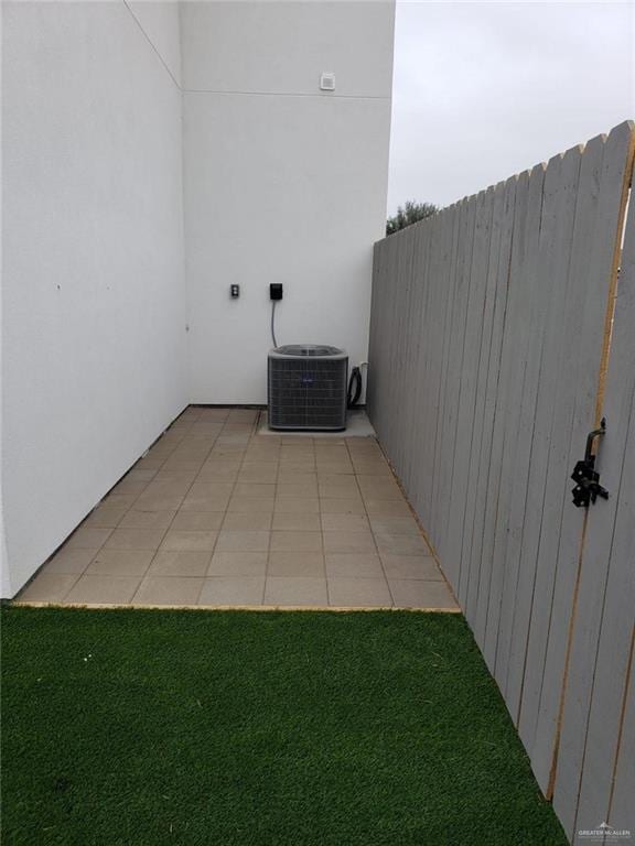 view of patio featuring central AC unit and fence