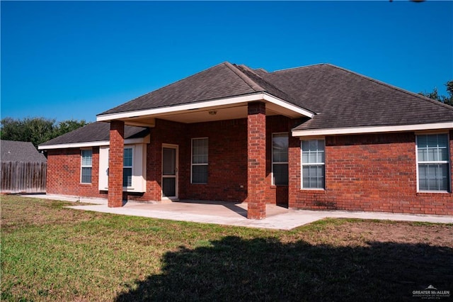 rear view of property with a yard and a patio