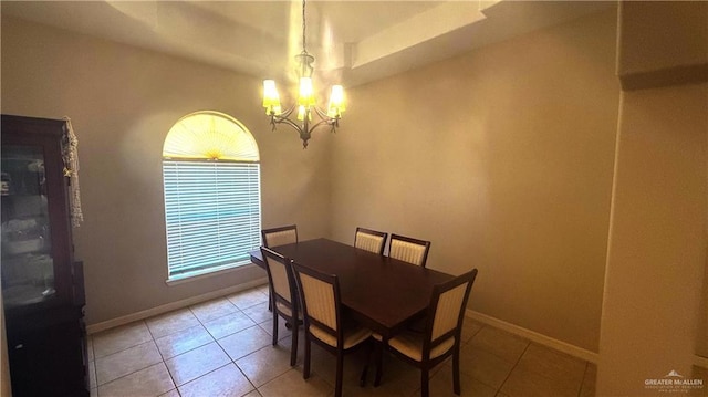 tiled dining room with a chandelier