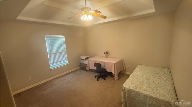 unfurnished bedroom featuring carpet flooring, a tray ceiling, and ceiling fan